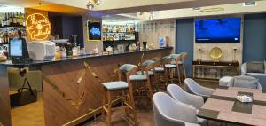 eine Bar in einem Restaurant mit Stühlen und einer Theke in der Unterkunft Somerset City Centre Atyrau in Atyrau