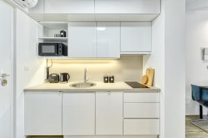 eine Küche mit weißen Schränken und einer Spüle in der Unterkunft Apartment Hica - Cupra in Dubrovnik