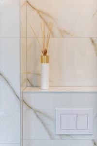 ein weißes Regal mit einer Vase mit Gras darin in der Unterkunft Apartment Hica - Cupra in Dubrovnik