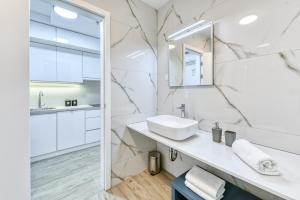 ein weißes Badezimmer mit Waschbecken und Spiegel in der Unterkunft Apartment Hica - Cupra in Dubrovnik