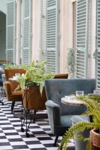 un patio con sedie, tavoli e piante in vaso di Demeures de Campagne Domaine de Maffliers - L'Isle-Adam a Maffliers