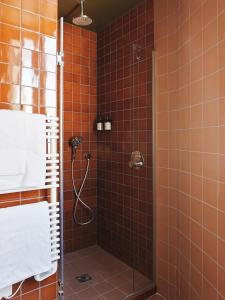 La salle de bains est pourvue d'une douche avec du carrelage orange. dans l'établissement Hotel Orphée - Orso Hotels, à Paris