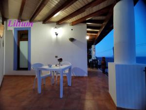 a dining room with a white table and chairs at Stella del Mattino in Lipari