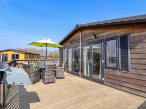 a deck with chairs and an umbrella at Skylarks in Hengrave