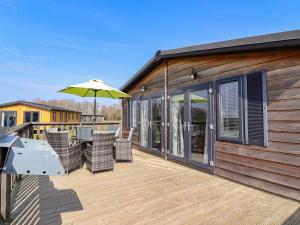 a deck with chairs and an umbrella at Skylarks 