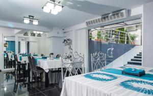 a dining room with tables and chairs and a staircase at Hotel Jolie Apartments in Galaţi