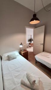 a bedroom with two beds and a table with a lamp at Opening Doors Vilassar. Family house Beach & Relax in Vilassar de Mar