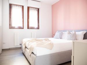 - une chambre avec un grand lit blanc et 2 fenêtres dans l'établissement The Best Rent - Apartment near Arco della Pace, à Milan
