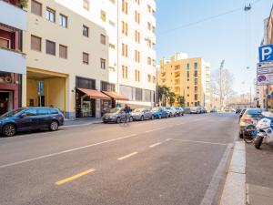 une personne circulant à vélo dans une rue avec des voitures garées dans l'établissement The Best Rent - Apartment near Arco della Pace, à Milan