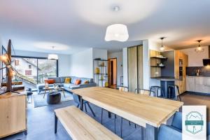 cocina y sala de estar con mesa de madera en Villa on the shores of Lake Annecy en Duingt