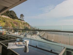 - une vue sur la plage depuis un balcon avec une tasse de café dans l'établissement 18 Abbey Sands, à Torquay