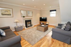 a living room with two couches and a fireplace at BY THE BEACH cottage, dogs welcome in Saint Merryn
