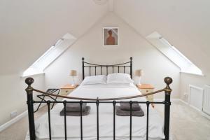 a bedroom with a black bed in a attic at BY THE BEACH cottage, dogs welcome in Saint Merryn