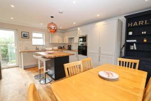 a kitchen and dining room with a wooden table at BY THE BEACH cottage, dogs welcome in Saint Merryn