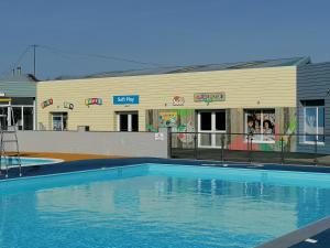 a large swimming pool in front of a building at Sycamores Caravan in Helston