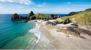 an aerial view of a beach with rocks and the ocean at Sycamore Caravan in Helston