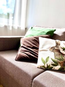 un sofá con almohadas con una foto de un ciervo. en Cesis Boulevard Apartments en Cēsis