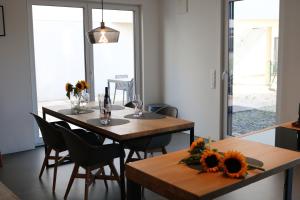 a dining room with two tables and chairs with flowers on them at Wave Penthouses in Neusiedl am See