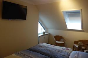 een slaapkamer met een bed en een televisie aan de muur bij MEI27a Ferienwohnung Ostseetraum in Niendorf