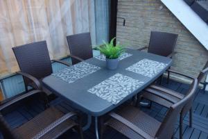 einem blauen Tisch mit Stühlen und einer Pflanze auf einer Terrasse in der Unterkunft MEI27a Ferienwohnung Ostseetraum in Niendorf