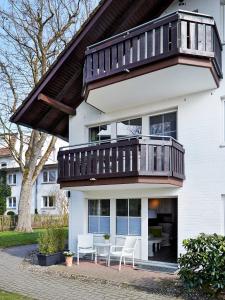 ein Haus mit einem Balkon, einem Tisch und Stühlen in der Unterkunft TRA7d Ferienwohnung Kossmann in Niendorf