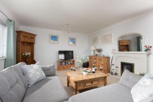 a living room with a couch and a table at Driftwood, Carbis Bay in Carbis Bay