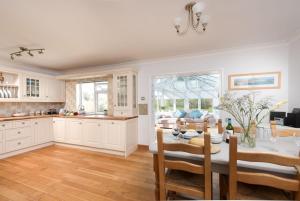 a kitchen and dining room with a table and chairs at Driftwood, Carbis Bay in Carbis Bay
