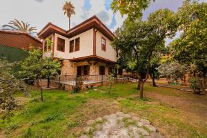 an old house with a roof on top of a yard at Zemira Garden Hotel in Antalya