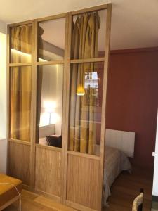 un grande armadio in legno in una camera con un letto di Suite confortable sur le canal Saint-Martin / République a Parigi