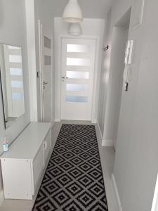 un corridoio con porta bianca e pavimento in bianco e nero di Apartament Anita a Mielec