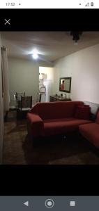 een woonkamer met een rode bank in een kamer bij Flavia Aluguel Temporada in Cabo Frio