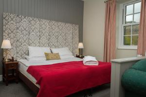 a bedroom with a large bed with a red blanket at Woolpack Inn in Eskdale