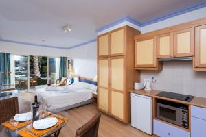 a kitchen and living room with a bed in a room at Paphos Gardens Holiday Resort in Paphos City