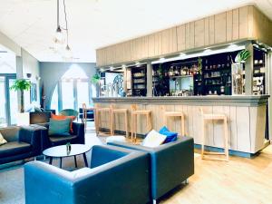 a lobby with couches and a bar with a counter at Hippotel in Le Touquet-Paris-Plage