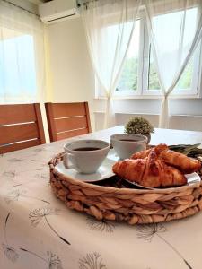 a table with a plate of chicken and two cups of coffee at Apartments Dia in Zaostrog