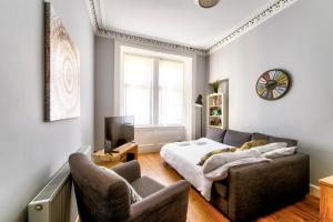 a living room with a couch and a bed and a tv at Edinburgh City Central Apartment Sleeps 6 Free Parking in Edinburgh
