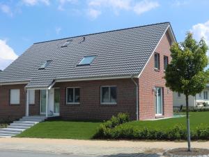 a red brick house with a gray roof at Ferienwohnung Feldblick in Grömitz