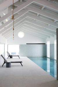 a swimming pool with a bench in a room at Torre de Palma Wine Hotel, Montforte, a Member of Design Hotels in Monforte