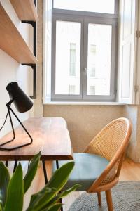 mesa y sillas en una habitación con ventana en Lindo, funcional e charmoso espaço - Porto - APT H en Oporto