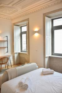 1 dormitorio con 2 camas y 2 ventanas en Lindo, funcional e charmoso espaço - Porto - APT H en Oporto