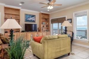 ein Wohnzimmer mit einem Sofa und einem TV in der Unterkunft Off The Hook - Very private lot with amazing gulf views perfect for your family beach vacation home in Dauphin Island