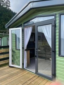 a sliding glass door on a house with a deck at Swift Bordeaux in Dunoon