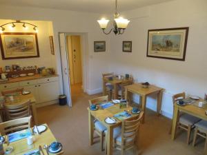 een eetkamer met houten tafels en stoelen bij Hillside Bed & Breakfast in Kendal