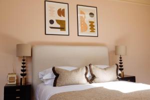 a bedroom with a bed with two lamps and two pictures at The Yard in Bath Hotel in Bath