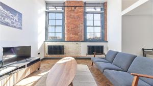 a living room with a couch and a fireplace at No 1 at Simpson Street Apartments Sunderland in Sunderland