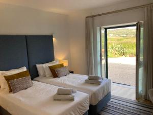 a bedroom with two beds and a sliding glass door at Quinta da Luz - A Luxury Boutique B&B in Silves