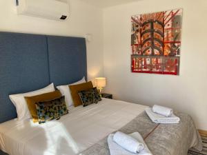 - une chambre avec un grand lit blanc orné d'une peinture murale dans l'établissement Quinta da Luz - A Luxury Boutique B&B, à Silves