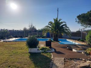 a swimming pool with a wooden deck in a yard at Quinta Cunte - Casa Sobreiro in São Luis