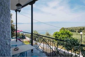 balkon ze stołem i widokiem na wodę w obiekcie Panoramic sea & mountain view villa w mieście Afissos