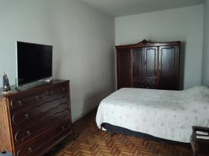 a bedroom with a bed and a dresser with a flat screen tv at Casa ótima e localização excelente em Aparecida-SP in Aparecida